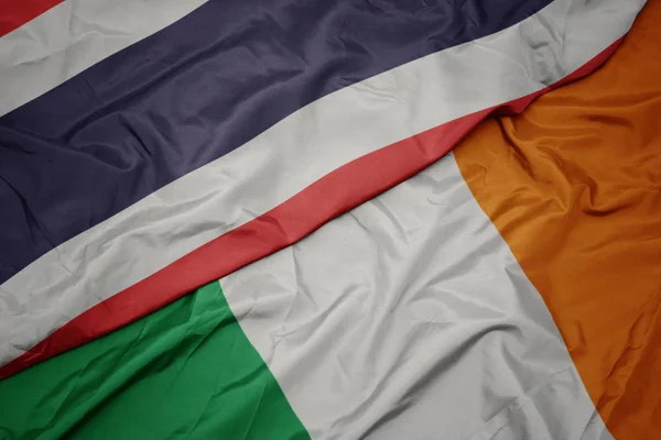 Mávající barevná vlajka Irska a národní vlajky Thajska. — Stock fotografie