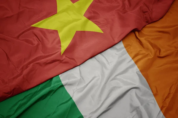 Waving colorful flag of ireland and national flag of vietnam. — Stock Photo, Image