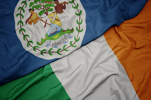 Waving colorful flag of ireland and national flag of belize. — Stock Photo, Image