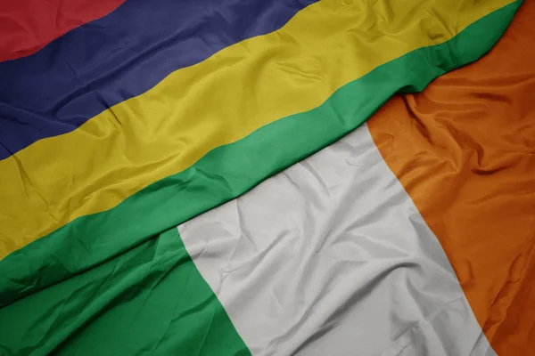 Waving colorful flag of ireland and national flag of mauritius. — Stock Photo, Image