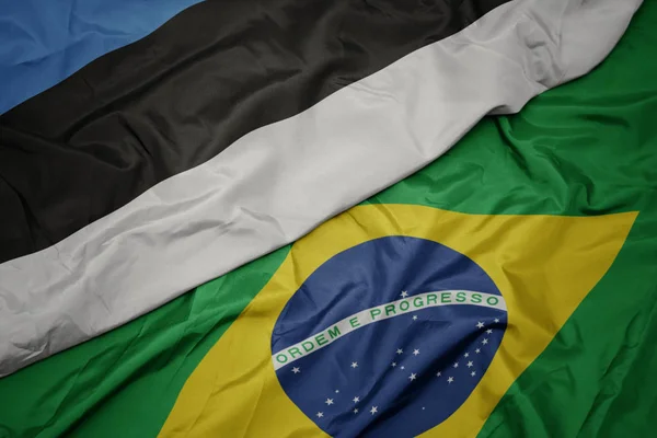Ondeando colorida bandera de Brasil y bandera nacional de estonia . —  Fotos de Stock