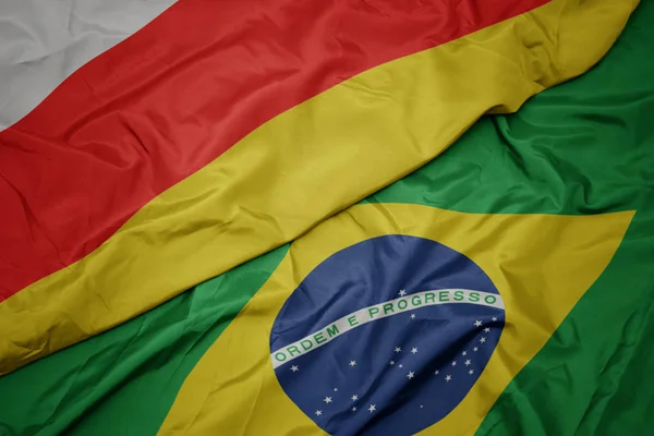 Waving colorful flag of brazil and national flag of south ossetia. — Stock Photo, Image