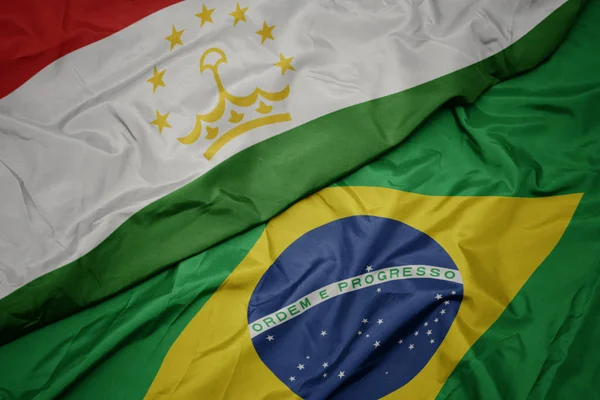 Размахивая красочным флагом Бразилии и национальным флагом Таджикистана . — стоковое фото
