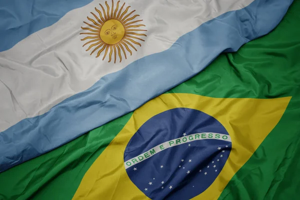 Vinka färgglada flagga av Brasilien och nationella flaggan i Argentina. — Stockfoto