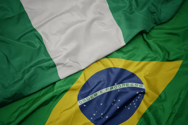 Ondeando colorida bandera de Brasil y bandera nacional de Nigeria . — Foto de Stock