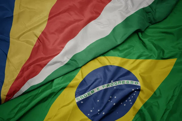 Ondeando colorida bandera de Brasil y bandera nacional de Seychelles . — Foto de Stock