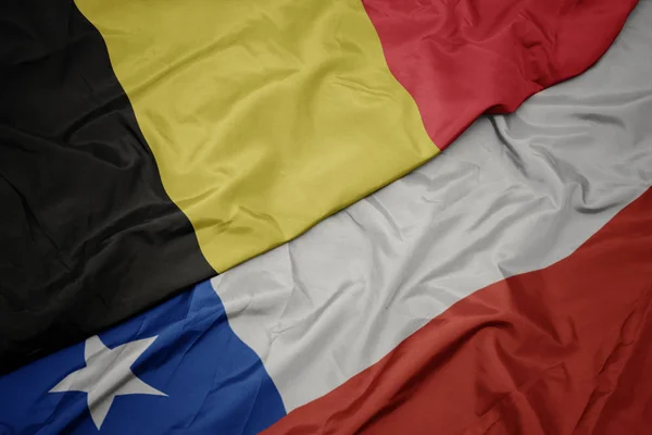 Zwaaiende kleurrijke vlag van Chili en de nationale vlag van België. — Stockfoto