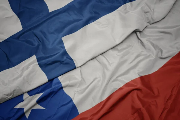 Mávající barvitá vlajka Chile a národní vlajka Finska. — Stock fotografie