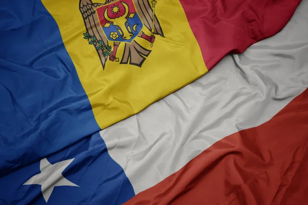 Ondeando colorida bandera de chile y bandera nacional de moldavia . —  Fotos de Stock