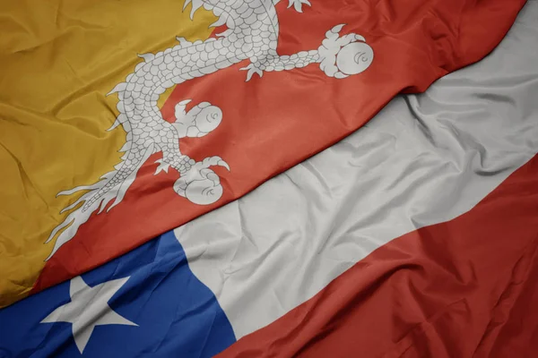 Falujące kolorowe flagi Chile i flagi narodowej Bhutanu. — Zdjęcie stockowe