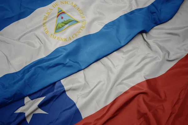 Ondeando colorida bandera de chile y bandera nacional de nicaragua . — Foto de Stock