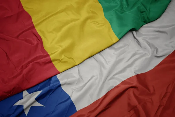 Schwenken bunte chilenische Flagge und Nationalflagge von Guinea. — Stockfoto
