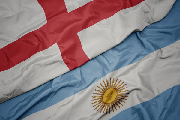 Ondeando colorida bandera de Argentina y bandera nacional de Inglaterra . —  Fotos de Stock