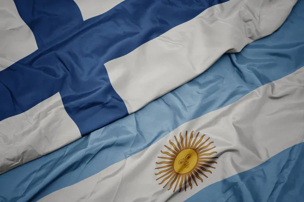 Waving colorful flag of argentina and national flag of finland. — Stock Photo, Image