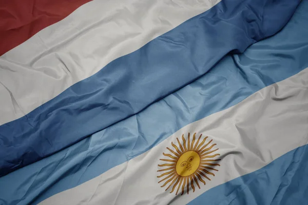 Размахивая красочным флагом Аргентины и национальным флагом Луксембура . — стоковое фото