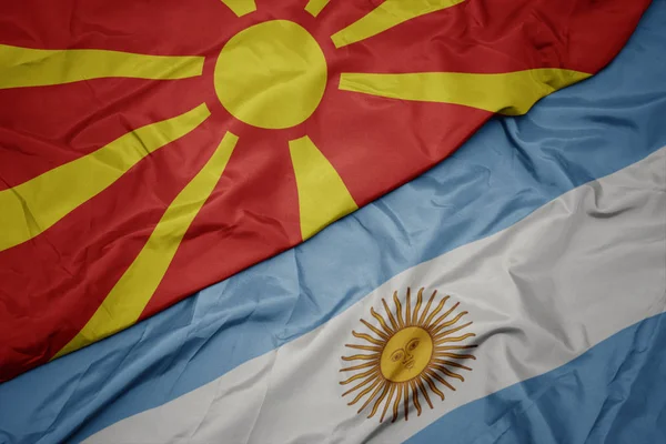 Acenando bandeira colorida da argentina e bandeira nacional da macedônia . — Fotografia de Stock