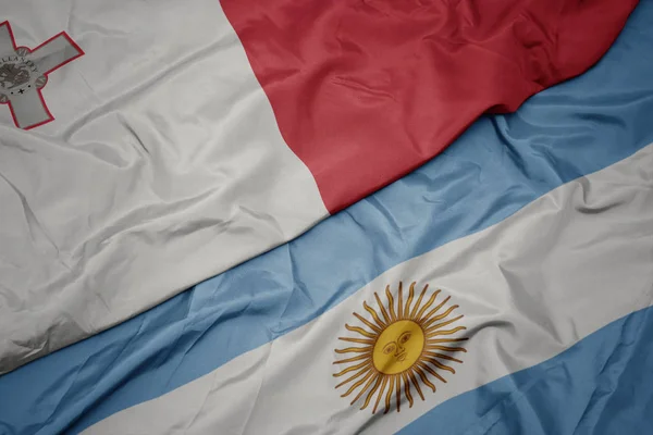 Ondeando colorida bandera argentina y bandera nacional de malta . —  Fotos de Stock