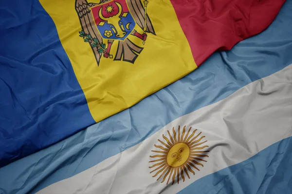 Ondeando colorida bandera de Argentina y bandera nacional de Moldavia . —  Fotos de Stock