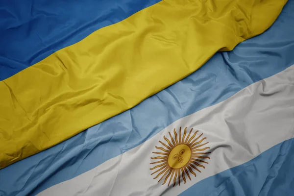 Waving colorful flag of argentina and national flag of ukraine. — Stock Photo, Image