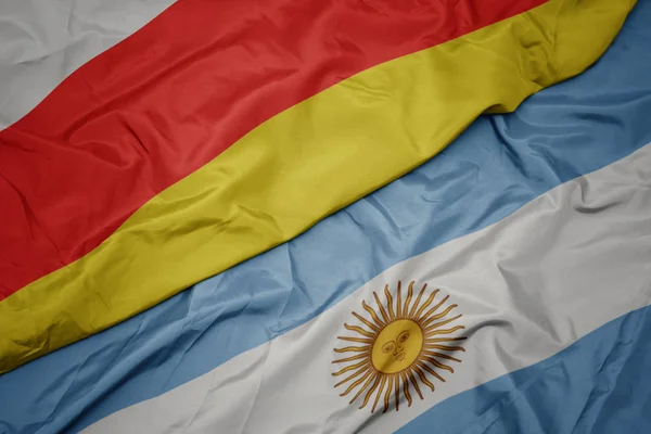 Argentína színes zászlója és a Dél-Oszétia nemzeti zászlaja. — Stock Fotó