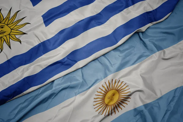 Waving colorful flag of argentina and national flag of uruguay. — Stock Photo, Image