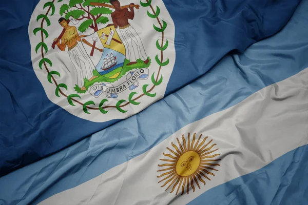 Ondeando colorida bandera de Argentina y bandera nacional de Belice . — Foto de Stock