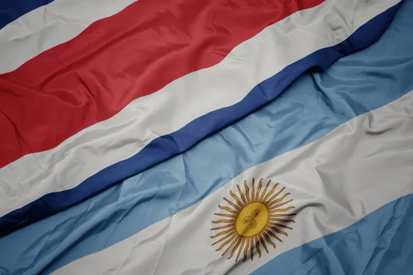 Размахивая красочным флагом Аргентины и национальным флагом Коста-Рики . — стоковое фото