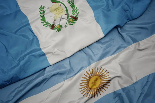 Ondeando colorida bandera argentina y bandera nacional de guatemala . —  Fotos de Stock