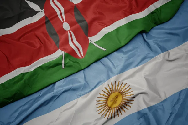 Agitant drapeau coloré de l'argentine et drapeau national du Kenya . — Photo