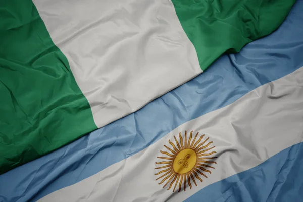 Waving colorful flag of argentina and national flag of nigeria. — Stock Photo, Image