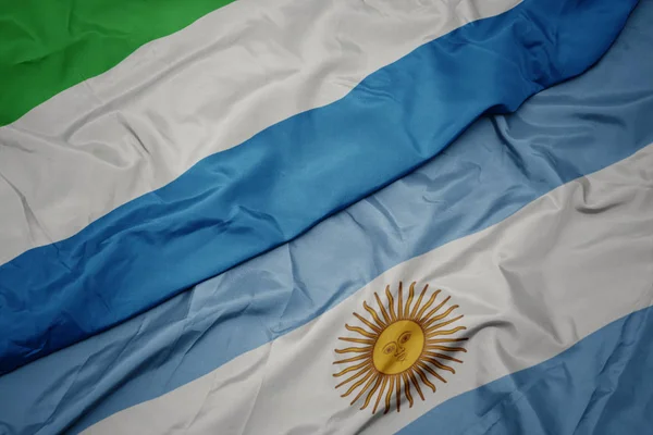 挥舞着五颜六色的阿根廷国旗和塞拉利昂国旗. — 图库照片