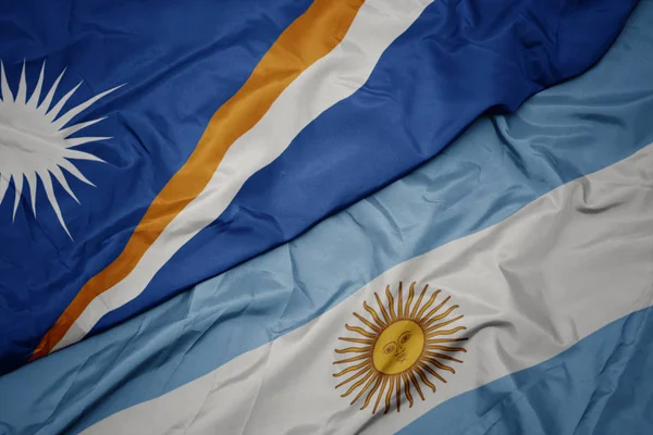 Waving colorful flag of argentina and national flag of Marshall Islands . — Stock Photo, Image