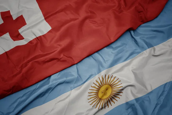 Waving colorful flag of argentina and national flag of Tonga . — Stock Photo, Image