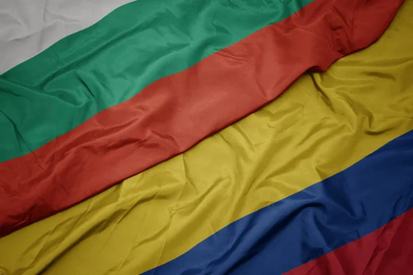 Acenando bandeira colorida da colômbia e bandeira nacional da bulgaria . — Fotografia de Stock