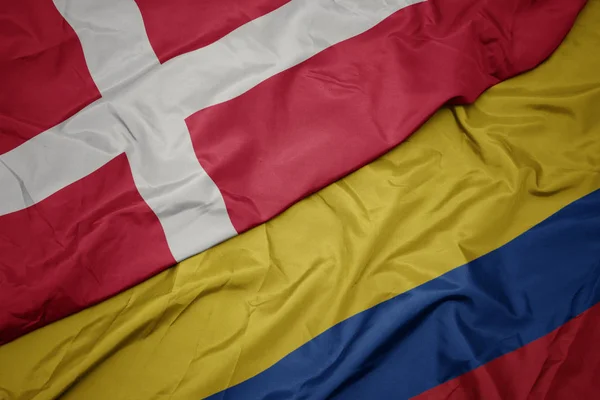 Waving colorful flag of colombia and national flag of denmark. — Stock Photo, Image