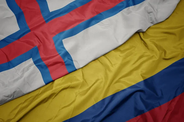 Sventolando bandiera colorata della colombia e bandiera nazionale delle isole Faroe . — Foto Stock