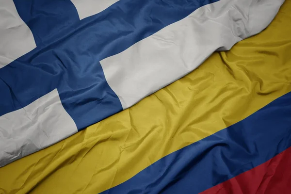 Waving colorful flag of colombia and national flag of finland. — Stock Photo, Image