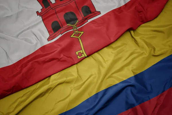 Ondeando colorida bandera de colombia y bandera nacional de gibraltar . —  Fotos de Stock