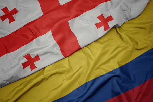 Sventola bandiera colorata della colombia e bandiera nazionale della georgia . — Foto Stock