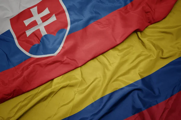 Zwaaiende kleurrijke vlag van Colombia en de nationale vlag van Slowakije. — Stockfoto