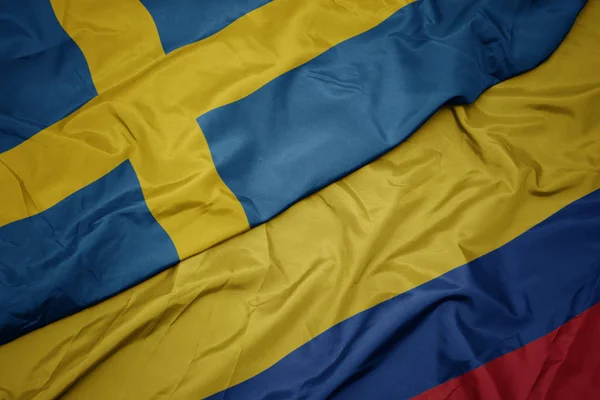 Falujące kolorowe flagi Kolumbii i flagi narodowej Szwecji. — Zdjęcie stockowe