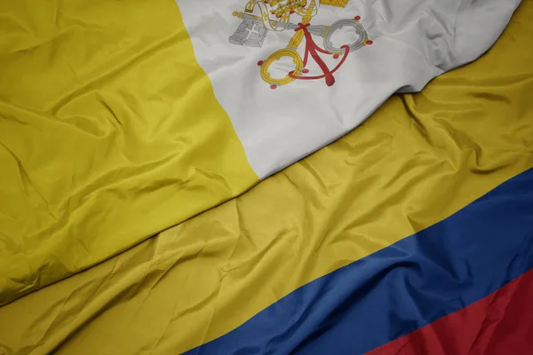 Sventolando bandiera colorata della colombia e bandiera nazionale della città vaticana . — Foto Stock