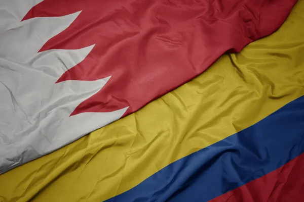 waving colorful flag of colombia and national flag of bahrain.