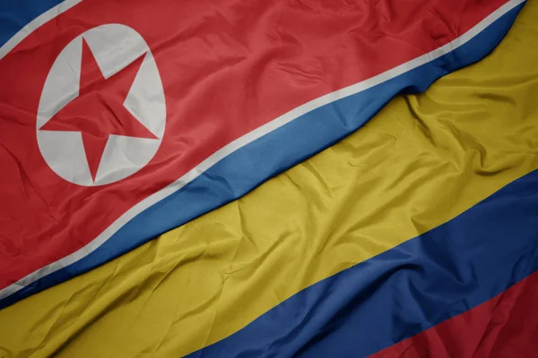 Zwaaiende kleurrijke vlag van Colombia en de nationale vlag van Noord-Korea. — Stockfoto