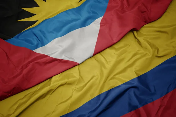Falujące kolorowe flagi Kolumbii i flagi narodowej Antigua i Barbuda. — Zdjęcie stockowe