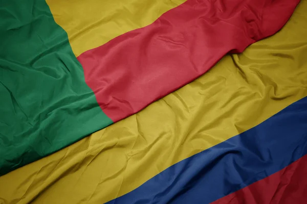 Zwaaiende kleurrijke vlag van Colombia en de nationale vlag van Benin. — Stockfoto