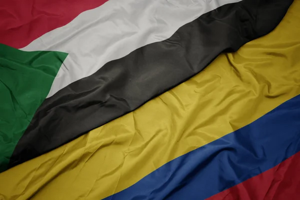 Waving colorful flag of colombia and national flag of sudan. — Stock Photo, Image