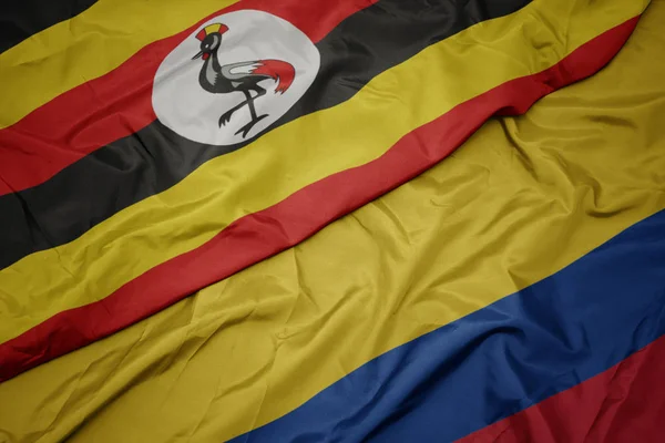 Размахивая красочным флагом Колумбии и национальным флагом Уганды . — стоковое фото