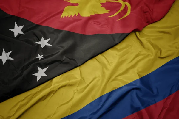 Sventolando bandiera colorata della colombia e bandiera nazionale di Papua Nuova Guinea  . — Foto Stock