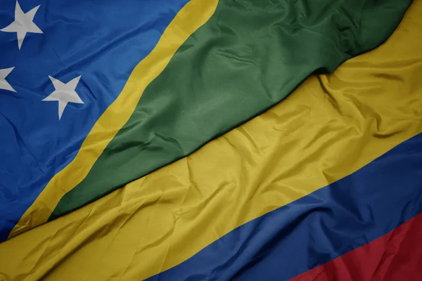 Acenando bandeira colorida da colômbia e bandeira nacional das Ilhas Salomão  . — Fotografia de Stock